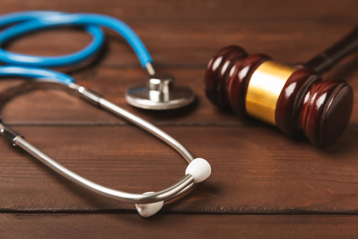 A stethoscope and hammer on a desk. Medical malpractice, personal injury lawyer, and healthcare legal aspects concept.Lawyer.Legal definition of medical negligence. Law concept.Healthcare and Medicine